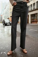 Jeans tobilleros de tiro alto color negro, corte recto y cinco bolsillos.