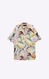 Camisa de manga corta con estampado de hojas en tonos naranja, verde y rosa sobre fondo blanco. Corte oversize.