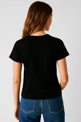 Remera negra de algodón con estampado de flores azules y texto "Let Love In".