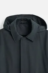 Parka relaxed fit confeccionada en tejido técnico repelente al agua. Interior acolchado desmontable. Cuello solapa con capucha desmontable. Manga larga con puño ajustable con botones a presión. Bolsillos de vivo en cadera. Bajo con abertura central en espalda. Cierre frontal con cremallera oculta por solapa con botones a presión. Chaleco interior acolchado y desmontable con cuello pico y manga sisa.