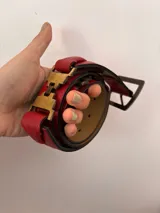 Cinto de cuero marrón con hebilla metálica plateada y doble pasador.