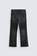 Pantalón de jean celeste de corte flare, con cinco bolsillos, efecto lavado y bajo con acabado irregular.