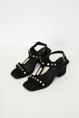 Sandalias de cuero color bordó, con taco cuadrado y tiras con apliques metálicos dorados.