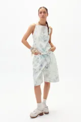 Bermuda de denim con estampado floral en tonos celeste, lila y verde.