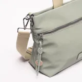 Bandolera de material sintético color verde salvia, con dos cierres frontales horizontales y un parche rectangular en la parte inferior central. Posee asas cortas de tela color beige y una correa larga ajustable del mismo color. Incluye un accesorio colgante de cordones trenzados en verde claro y un dije de madera.