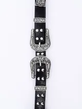 Cinto negro de cuero con hebilla metálica plateada con diseño floral.