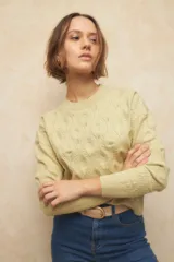 Sweater tramado color blanco con diseño de trenzas y pequeños calados, de manga larga y cuello a la base.