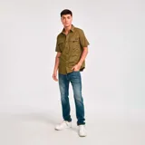 Camisa de manga corta color verde oliva con dos bolsillos de parche en el pecho con cierre de solapa y botón. Logo de Caterpillar bordado en la solapa del bolsillo izquierdo. Corte recto y cierre frontal con botones.