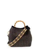 Bolso tipo cubo tejido en tonos marrón y negro, con asa superior de bambú y correa bandolera de tela con diseño geométrico.