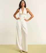 Pantalón de vestir blanco, de corte palazzo, con trabillas en la cintura, bolsillos laterales y pliegues delanteros.