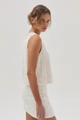 Top de lentejuelas color blanco, sin mangas y con espalda cruzada.