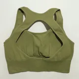 Top deportivo gris con breteles anchos y espalda deportiva.