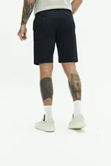 Bermuda de gabardina azul marino con logo bordado, bolsillos laterales y traseros, cierre con cremallera y botón, y presillas para cinturón.