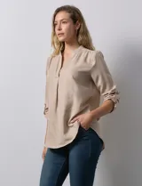 Blusa color beige de poliéster con escote en V y mangas 3/4 regulables con presilla y botón.