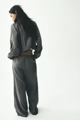 Pantalón palazzo color gris topo de tejido fluido, con cintura elástica ajustable con cordones y bolsillos laterales.
