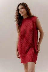 Vestido corto tejido color beige, sin mangas y con cuello redondo.