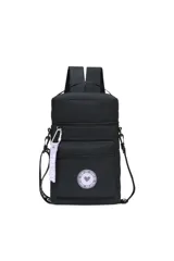 Mochila matera celeste con detalles en negro, con correas de mochila y correa larga para usar como bolso. Tiene un bolsillo frontal con cierre y un aplique circular con un corazón. Incluye un llavero naranja con la palabra 'TRENDY'.