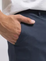 Bermuda de lino color negro, corte recto, con bolsillos laterales y cierre frontal.