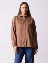 Camisa marrón de lyocell, marca Dash. Cuello con solapa y abertura central con botones. Largo de manga regulable con presilla y botón. Delantera con bolsillos aplicados.