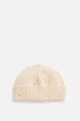 Gorro de punto color crudo, tejido en hilatura de algodón, con vuelta y efecto de roturas.