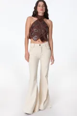 Jean acampanado color crudo, con cintura alta y detalles de costura visibles.