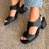 Sandalias de cuero vacuno color marrón con textura tipo cocodrilo, taco ancho y plataforma. Diseño con puntera descubierta y tira ancha sobre el empeine con aberturas laterales. Cierre con hebilla en el tobillo.