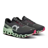 Championes de running On Cloudmonster 2, color negro con detalles en verde y rosa.