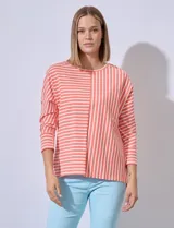 Remera de algodón con estampado a rayas horizontales y verticales en color naranja y blanco.