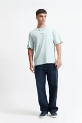 Remera azul de manga corta con corte oversize y cuello redondo. Estampado en la espalda con la frase "Cookies & Milk" y dibujos de una galleta y un cartón de leche.