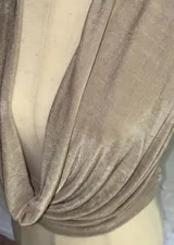 Conjunto color beige compuesto por un top halter con escote drapeado y una falda larga ajustada.