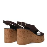 Sandalia de plataforma alta con base de corcho, capellada de tiras cruzadas de gamuza color beige y pulsera ajustable con hebilla metálica dorada.