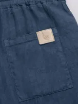 Short confeccionado en lino premium de mayor gramaje, con cintura elástica y cordón de algodón, y bolsillos laterales.