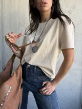 Remera beige de algodón con cuello redondo y mangas cortas. Corte recto y holgado.