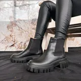 Bota de cuero negra de media caña con plataforma y suela track.