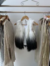 Chaleco de pelo largo blanco con degradé a negro, forrado en su interior.