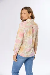 Camisa de manga larga con estampado floral en tonos rosa, naranja y lila. Confeccionada en lino y algodón, con cuello clásico, cierre frontal con botones y puños abotonados.