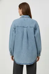 Sobrecamisa de denim negro, con cuello camisero, botones frontales y dos bolsillos de parche con tapa en el pecho. Presenta un calce holgado y mangas largas.