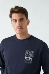 Remera de manga larga color marrón con estampado en el pecho.