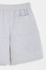 Bermuda de algodón gris melange, con cintura elástica y cordón de ajuste.