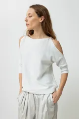 Sweater de tejido de punto fino con efecto lurex brillante, color plateado claro. Presenta un escote bote y aberturas en los hombros (cold shoulder) con mangas tres cuartos.