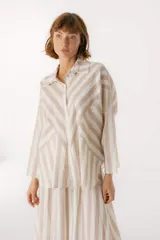 Camisa celeste y blanca a rayas verticales, de corte holgado y mangas largas.
