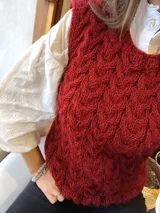 Chaleco tejido a mano color ladrillo con patrón de trenzas.
