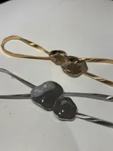 Cinto de metal dorado con hebilla doble irregular.