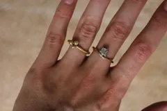 Anillo dorado con una piedra blanca engarzada.