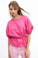 Blusa color verde lima, de manga tres cuartos con leve volumen y largo hasta la cadera. Incluye cinto extraíble en espalda que permite anudar para modificar la silueta.