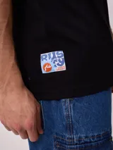 Remera de algodón con lavado, color celeste verdoso, de corte holgado (loose fit) y cuello redondo. Presenta un pequeño estampado gráfico en el pecho.