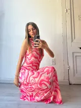 Vestido largo de fiesta con estampado abstracto en tonos rosados y blancos, cuello halter y corte ajustado al cuerpo.
