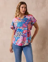 Blusa estampada con motivos florales en tonos rosa, azul y naranja. Tiene cuello en V y mangas cortas con volados.