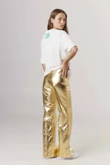 Pantalón de lino color dorado con acabado metalizado, corte recto y tiro alto.