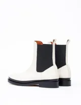 Bota Chelsea color crema de cuero vacuno, con elástico lateral negro, suela de cuero y taco de 2,5 cm. Hecha a mano en Argentina.